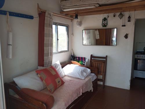 a bedroom with a bed in a room with a window at El Navegante in Cabo Polonio