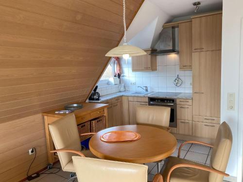 een kleine keuken met een houten tafel en stoelen bij Haus-Hooge-Whg-04 in Sankt Peter-Ording