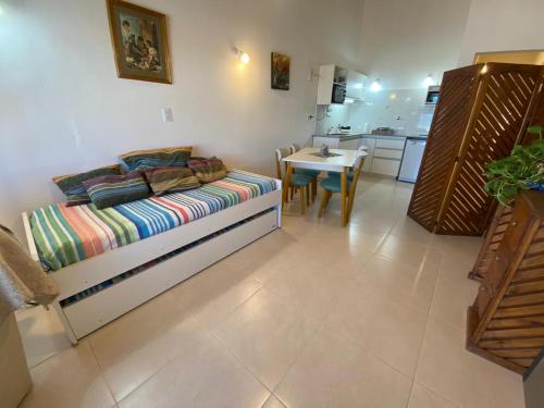 ラス・グルータスにあるDepto Frente a la playa, con vista al marのベッドとテーブルとキッチンのある寝室