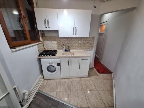 eine kleine Küche mit Spüle und Waschmaschine in der Unterkunft Amazing TaKSIM Apartment 2 in Istanbul