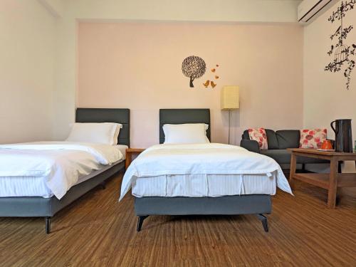 1 dormitorio con 2 camas y sofá en Hoyu''s House B&B, en Lugu