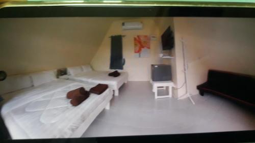Cette chambre comprend 2 lits et une télévision. dans l'établissement Jungle view phulanka, à Ban Nong Kham Tai