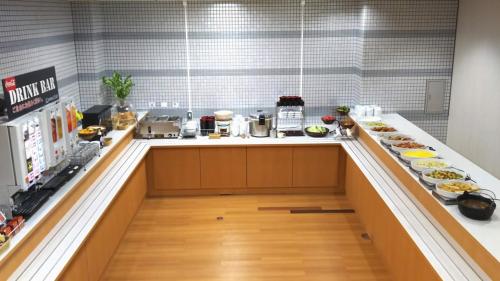 Hotel Alpha-One Joetsu في جويتسو: مطبخ مع كونتر مع لوحات من الطعام