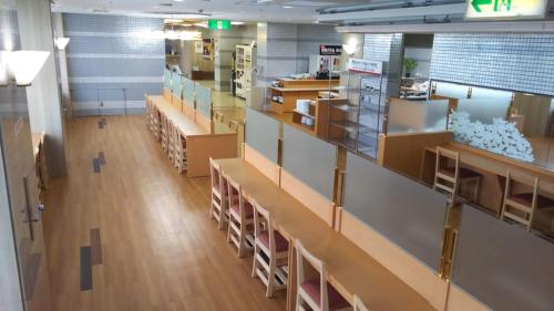 een lege bibliotheek met veel tafels en stoelen bij Hotel Alpha-One Joetsu in Joetsu