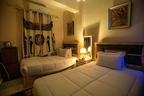 Ein Bett oder Betten in einem Zimmer der Unterkunft Bella Casa Pyramids Inn