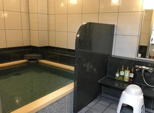 uma casa de banho com uma piscina de água num chuveiro em Hotel Alpha-One Takaoka em Takaoka