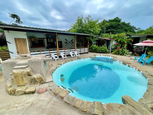 a large swimming pool with chairs and a house at Rema K A Y A K Lodge in Tena