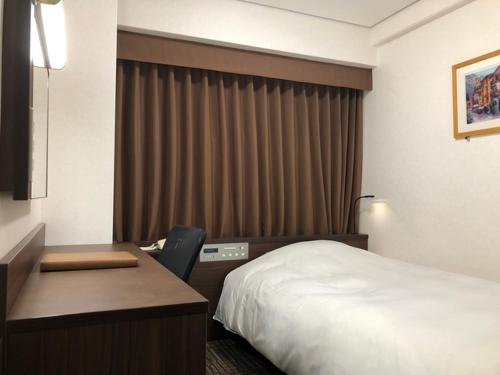 Ліжко або ліжка в номері Hotel Alpha-One Takaoka Ekimae
