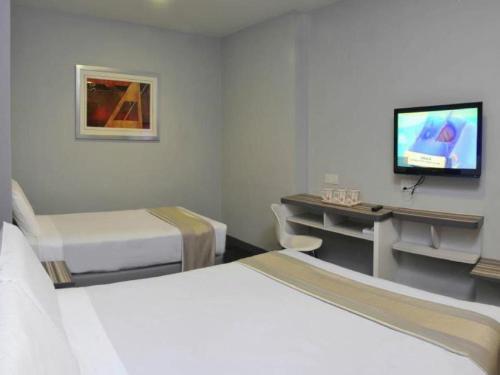 a hotel room with two beds and a television at Swing & Pillows - KL Sg Besi formerly known as U Pac Hotel in Kuala Lumpur