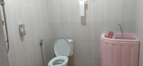 une salle de bains avec des toilettes et une poubelle rose dans l'établissement Pondok Wisata Botu Barani, à Gorontalo