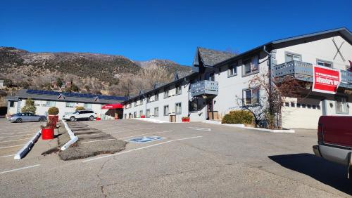 a parking lot in front of a white building at Adventure Inn - Glenwood Springs in Glenwood Springs