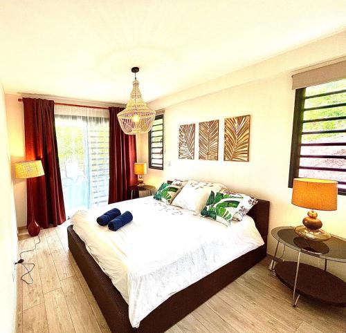 - une chambre avec un grand lit et un lustre dans l'établissement Pacific cosy home Bougainvilliers, à Punaauia
