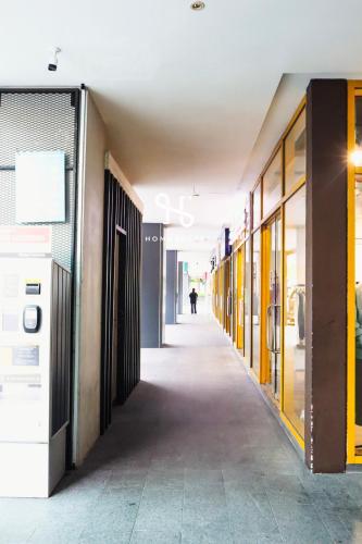 a hallway of a building with a person walking in the distance at Homesuite' Home at The Loft in Kota Kinabalu