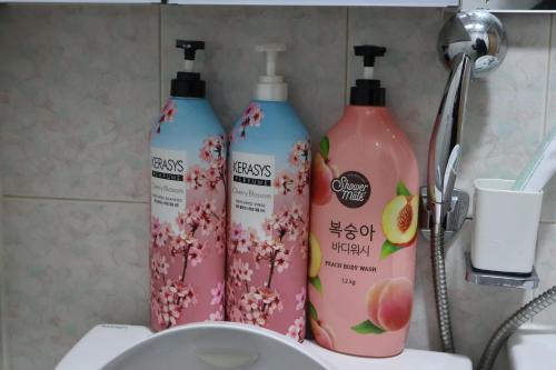 - deux bouteilles de nettoyant assises au-dessus d'un lavabo dans l'établissement Clover Stay, 2BR,1BA,mapo, free-wifi,, à Séoul