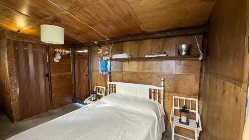 1 dormitorio con 1 cama en una habitación con paredes de madera en Cabo Polonio - Rancho 66, en Cabo Polonio