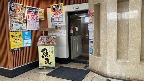 an entrance to a building with a sign in front of a door at Hotel Alpha-One Sabae in Sabae