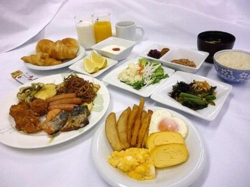 ein weißer Tisch mit Teller mit Lebensmitteln drauf in der Unterkunft Hotel Alpha-One Sabae in Sabae