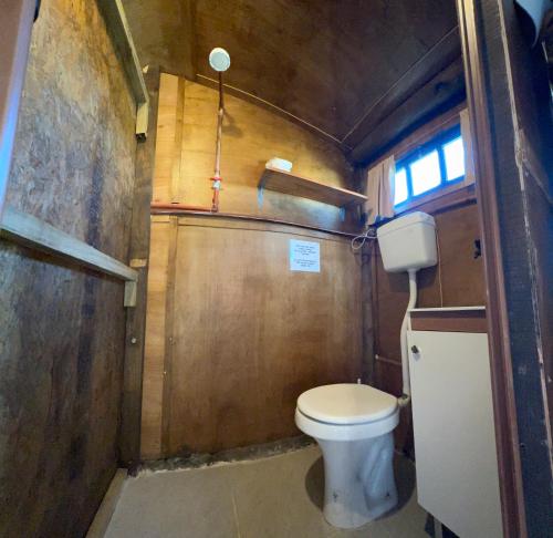 Elle comprend une petite salle de bains pourvue de toilettes et d'une fenêtre. dans l'établissement Cabo Polonio - Rancho 66, à Cabo Polonio