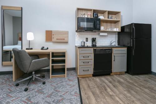 a small kitchen with a desk and a refrigerator at Candlewood Suites Lake Jackson by IHG in Lake Jackson
