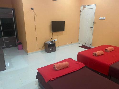 a room with two beds and a television in it at KOTOKOH INN in Machang
