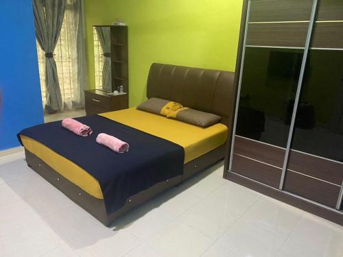 a bedroom with a bed with two pink pillows on it at KOTOKOH INN in Machang