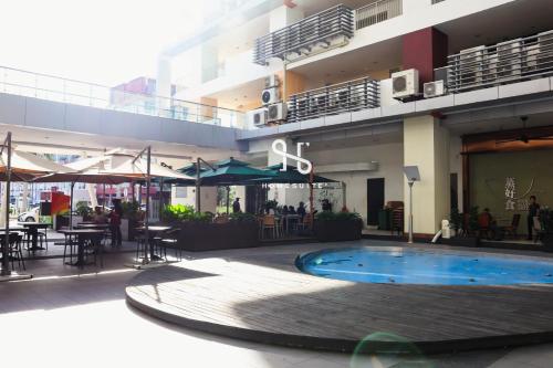 a building with a swimming pool in front of a building at Homi Breeze at Sutera Avenue 和逸微风 in Kota Kinabalu