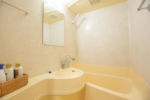a bathroom with a sink and a tub and a mirror at walk to JR Yoyogi sta.-DSYE in Tokyo