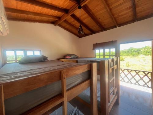 ein Schlafzimmer mit einem Bett und einem großen Fenster in der Unterkunft Cabaña El Cangrejo Azul - Blue Crab House in San Onofre