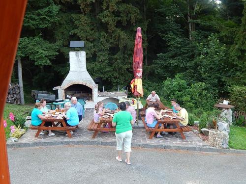 a group of people sitting at tables in front of a grill at Wellness penzion Harmonie Rohanov in Prachatice