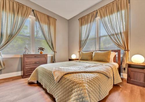 Un dormitorio con una cama y dos grandes ventanales. en The Green Door in Ybor, en Tampa