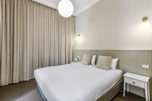 a bedroom with a large white bed and curtains at Aloha Central Platinum Apartments in Mount Gambier