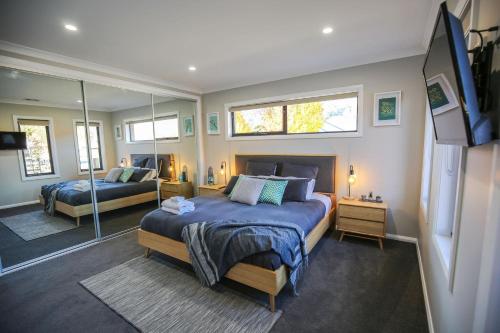 a bedroom with two beds and a mirror at Amaroo in Bright