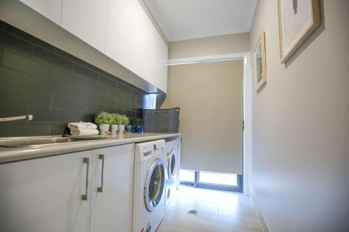 a kitchen with a sink and a washing machine at Amaroo in Bright