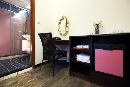 花蓮市的住宿－玫瑰花園民宿，一间带电视和带水槽的书桌的浴室