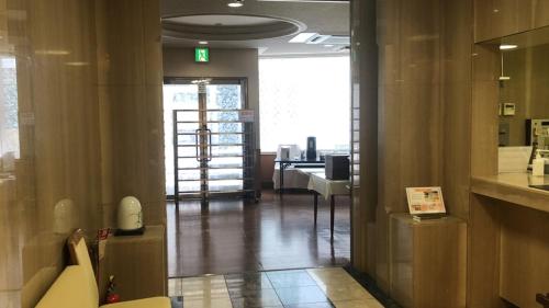 Hotel Alpha-One Takayama في تاكاياما: غرفة مع ممر مع غرفة مع طاولة