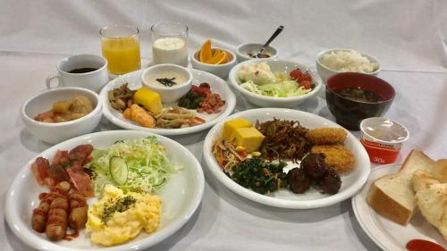 stół z wieloma talerzami jedzenia w obiekcie Hotel Alpha-One Takayama w mieście Takayama