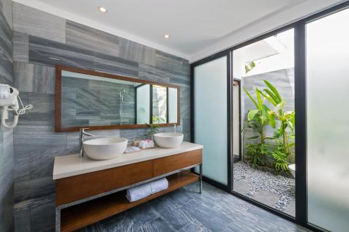 a bathroom with two sinks and a mirror at Cocoland River Beach Resort & Spa in Quảng Ngãi