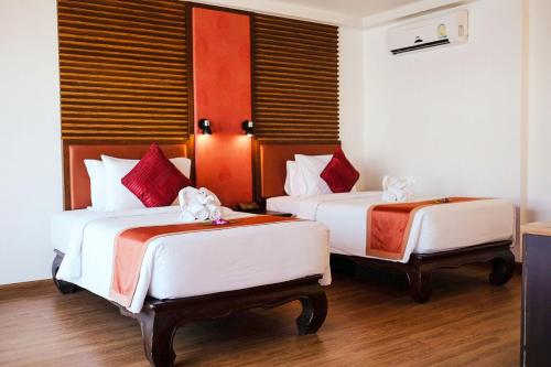 two beds in a room with red and white at Nipa Resort, Patong Beach - SHA Extra Plus in Patong Beach