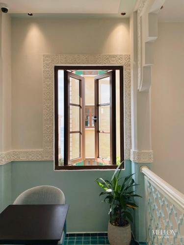 a mirror on a wall with a table and a chair at Mellon OASIS Phu Quoc in Phu Quoc
