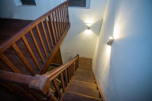 a wooden staircase with a light on the wall at Villa RISITHENMI in Ahangama