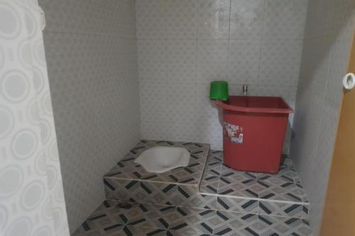 a bathroom with a toilet and a trash can at OYO 93493 Wira Residensia Syariah in Medan