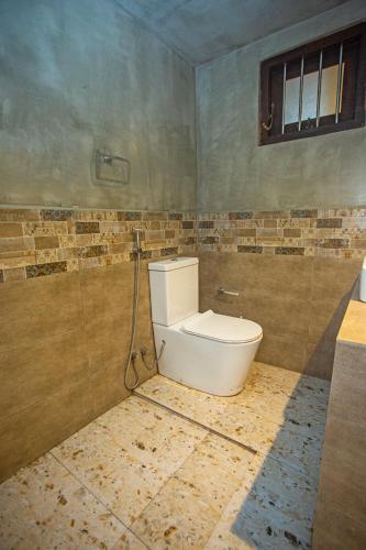 a bathroom with a toilet in a room at Villa RISITHENMI in Ahangama