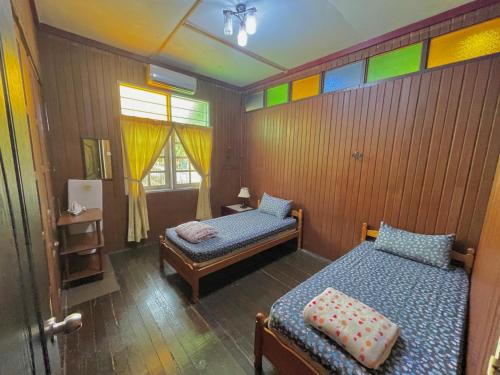 two beds in a room with colorful walls at Tamteh Homestay in Ayer Hitam