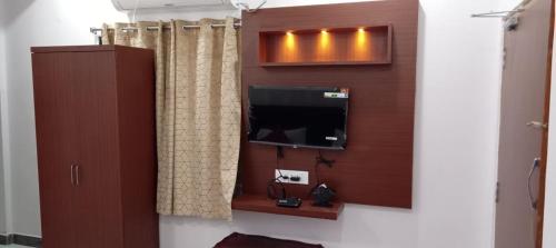 Camera con TV e parete di RK GRAND LUXURY AC ROOMS a Guntur