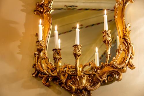 a gold chandelier with candles in front of a mirror at Thorngrove Manor in Stirling