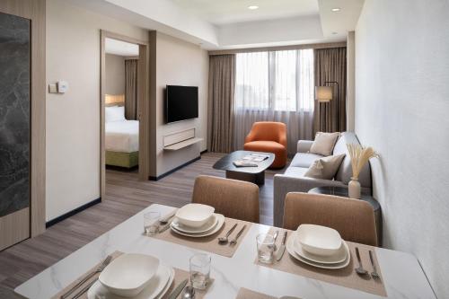 uma suite de hotel com uma sala de estar e um quarto em Park Avenue Clemenceau em Singapura