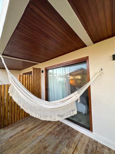 a hammock hanging from a ceiling in a room at Joju Bangalôs & Bistrô in Japaratinga