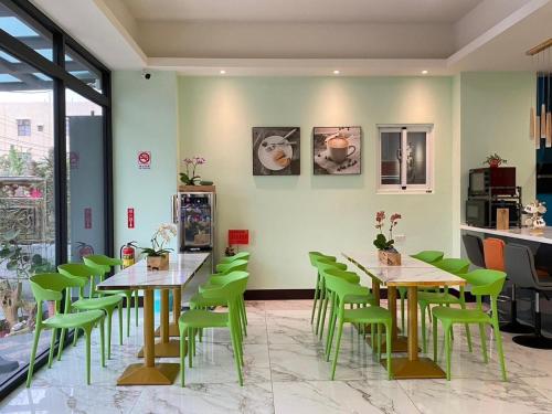 un restaurante con mesas verdes y sillas verdes en The sun never sets B&B, en Budai