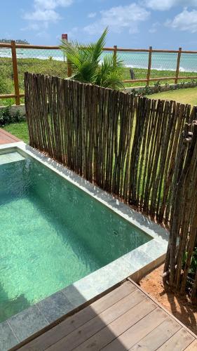 una piccola piscina accanto a una recinzione di legno di Joju Bangalôs & Bistrô a Japaratinga