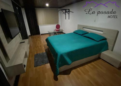 een slaapkamer met een bed met een groene deken bij Casa Guayacanes in Manizales